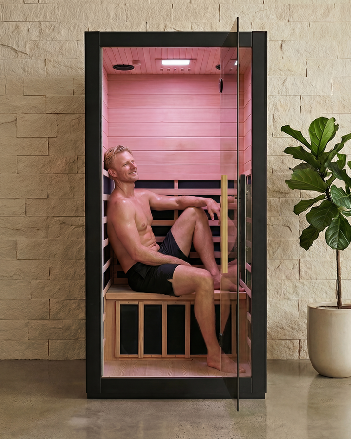 Man relaxing inside a XEN Infrared Sauna with open glass door